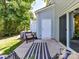 Relax in style on the cozy patio featuring a wicker chair, striped rug, and access to the yard at 3524 Auburn Curb Rd, Charlotte, NC 28217