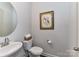 Stylish powder room with pedestal sink, framed art, and modern fixtures and finishes at 3524 Auburn Curb Rd, Charlotte, NC 28217