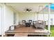 Covered back porch offers a ceiling fan and relaxing porch swing with wooded views at 365 Kinder Rd, Harmony, NC 28634