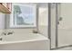 Bright bathroom features a soaking tub with shower and a window for natural light at 365 Kinder Rd, Harmony, NC 28634