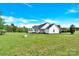 Side view of a white single-story house featuring a shed, covered porch, and large yard at 365 Kinder Rd, Harmony, NC 28634