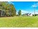 Spacious backyard view of a one-story white home with a lush green lawn and tree line at 365 Kinder Rd, Harmony, NC 28634