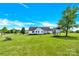 Rear exterior of home with a spacious yard, deck, hot tub, and elevated treehouse at 365 Kinder Rd, Harmony, NC 28634