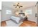 Cozy bedroom featuring hardwood floors, ceiling fan, and natural light from the windows at 3701 Slagle Dr, Charlotte, NC 28215