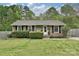 Traditional brick home with manicured lawn, black shutters, white trim, and a quaint, covered front porch at 3701 Slagle Dr, Charlotte, NC 28215