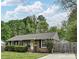 Charming brick home features a well-maintained front yard, a yellow front door, and a wooden fence at 3701 Slagle Dr, Charlotte, NC 28215