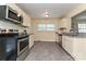 Updated kitchen features stainless steel appliances, granite countertops, and white cabinets with tile flooring at 3701 Slagle Dr, Charlotte, NC 28215
