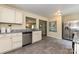 Bright kitchen with stainless steel dishwasher, white cabinets, gray countertops and tile floors, and an open view into the dining area at 3701 Slagle Dr, Charlotte, NC 28215