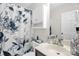 Bright bathroom with floral shower curtain, white vanity, and cabinet storage at 3790 Lynnview Ct, Maiden, NC 28650