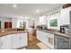 Bright kitchen featuring white cabinets and sink under window and view to dining area at 3790 Lynnview Ct, Maiden, NC 28650