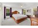 Spacious main bedroom featuring a large wood bed frame, soft gray carpet, and windows with views of mature trees at 380 Hamrick Rd # 1, Gastonia, NC 28056