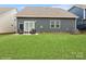 Spacious backyard with patio, chairs, lush lawn, and attractive gray home exterior at 4024 Whipcord Dr, Waxhaw, NC 28173