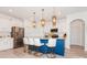 Modern kitchen with stainless steel appliances, white cabinets and a blue center island with decorative pendant lights at 4024 Whipcord Dr, Waxhaw, NC 28173