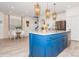 Beautiful kitchen island with white countertop, blue cabinetry, stainless steel appliances and stylish pendant lights above at 4024 Whipcord Dr, Waxhaw, NC 28173
