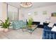 Bright living room with blue velvet sofa, patterned armchairs, decorative lighting and a glass coffee table at 4024 Whipcord Dr, Waxhaw, NC 28173