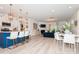 Open concept living room with modern furniture, fireplace, large windows and seamlessly connected to the kitchen and dining area at 4024 Whipcord Dr, Waxhaw, NC 28173