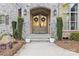 Close-up of double front doors framed by stone, sconces, and manicured greenery at 4025 Foxes Trl, Cramerton, NC 28032