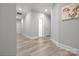 Hallway with light gray walls, light wood floors and several doors at 4025 Foxes Trl, Cramerton, NC 28032