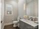 Well-lit powder room with patterned wallpaper, gray vanity, and decorative mirror at 4025 Foxes Trl, Cramerton, NC 28032