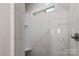 Shower featuring marble tile surround and accent window at 4025 Foxes Trl, Cramerton, NC 28032