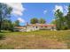 View of the backyard showcasing a spacious lawn and the house's exterior, including a red roof at 4205 Cahnnas Way, Waxhaw, NC 28173