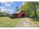 A charming red barn with covered storage on a property with lush greenery at 4205 Cahnnas Way, Waxhaw, NC 28173