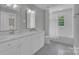 Bathroom with double vanity, black and white tiled floor, and bathtub with shower at 4205 Cahnnas Way, Waxhaw, NC 28173