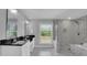 Modern bathroom with double sinks, black countertops, a glass-enclosed shower, and a soaking tub at 4205 Cahnnas Way, Waxhaw, NC 28173