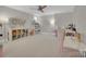 Spacious bonus room with neutral carpeting, fan, shelving, and multiple seating areas at 4205 Cahnnas Way, Waxhaw, NC 28173