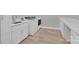 Updated laundry room featuring new appliances, white cabinetry and countertop, and wood flooring at 4205 Cahnnas Way, Waxhaw, NC 28173