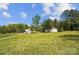 Expansive property featuring a main house and outbuilding with lush green lawn and mature trees at 4205 Cahnnas Way, Waxhaw, NC 28173