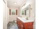 Bathroom featuring a double vanity with framed mirror, updated lighting, and a window at 424 Mirror Lake Rd, Salisbury, NC 28146