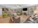 Open-concept living room with hardwood floors, fireplace, large windows, and comfortable seating for entertaining at 428 Winecoff Woods Nw Dr, Concord, NC 28027