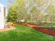 Landscaped backyard featuring a deck, green grass, and mulched flower beds at 431 Harvest Ter, Lake Wylie, SC 29710
