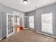 Carpeted room featuring French doors, two windows, and neutral gray walls, perfect for an office or guest room at 431 Harvest Ter, Lake Wylie, SC 29710