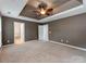 Large bedroom featuring tray ceilings with fan, neutral paint, and open doorway leading to bathroom and closet at 431 Harvest Ter, Lake Wylie, SC 29710