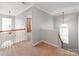 Upstairs hallway featuring carpet, white trim, and open access to the bedrooms at 431 Harvest Ter, Lake Wylie, SC 29710