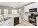 Modern kitchen with white cabinets, black appliances, and views to the outdoor deck at 431 Harvest Ter, Lake Wylie, SC 29710