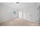 This carpeted bedroom features neutral walls, one window, and two doors for ample natural light and easy access at 4700 Aldersbrook Dr, Monroe, NC 28110