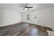 Bright room with fireplace, ceiling fan, wood-look floors, large windows, and a door leading to the outside at 4700 Aldersbrook Dr, Monroe, NC 28110