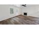 Bright room with fireplace, ceiling fan, wood-look floors, large windows, and a door leading to the outside at 4700 Aldersbrook Dr, Monroe, NC 28110