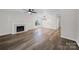Light-filled living room with modern wood-look floors, a cozy fireplace, and contemporary light fixture at 4700 Aldersbrook Dr, Monroe, NC 28110
