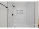 Gorgeous glass enclosed shower features white marble tiling and dark hardware at 4700 Aldersbrook Dr, Monroe, NC 28110