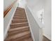 Carpeted staircase with white risers and handrail provides access to the upper levels of this house at 4700 Aldersbrook Dr, Monroe, NC 28110