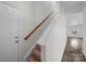 Carpeted stairs with wooden handrail lead to the upper level with luxury vinyl plank floors in this home at 4700 Aldersbrook Dr, Monroe, NC 28110