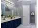 Well-lit bathroom with dual sinks, white marble floors, and navy blue cabinetry at 5025 Wicklow Dr, Gastonia, NC 28054