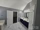 Bathroom features a double vanity and marble-look tile floor with a doorway to a closet at 5025 Wicklow Dr, Gastonia, NC 28054