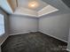 Room featuring plush carpet, neutral walls, tray ceiling, recessed lights, and a bright window at 5025 Wicklow Dr, Gastonia, NC 28054