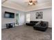 Spacious carpeted bonus room featuring a modern black sectional couch and plenty of space at 5025 Wicklow Dr, Gastonia, NC 28054