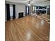Open-concept living room with a fireplace, hardwood floors, and a view into the kitchen at 5025 Wicklow Dr, Gastonia, NC 28054